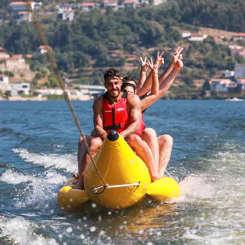 Pessoas divertidas em cima de um Banana Boat puxado por barco da Bello Giro no rio Douro